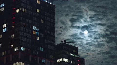Skyscraper and moving clouds in moonlight at night 스톡 동영상 165651460