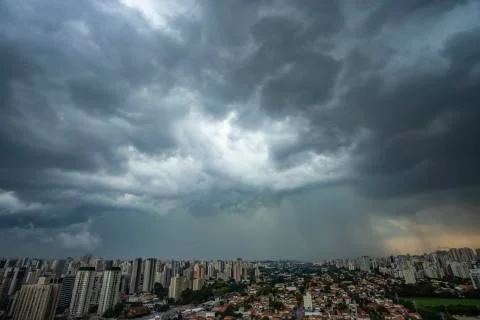 The skyscraper on the background of a rainy cloud. Stock Photos