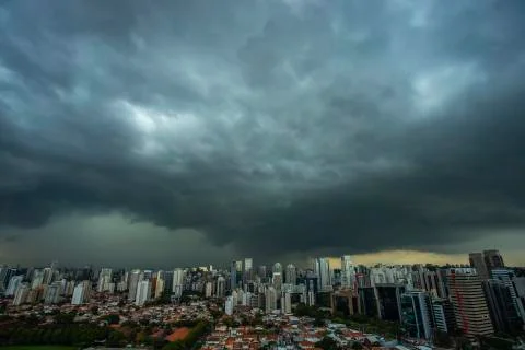 The skyscraper on the background of a rainy cloud. Stock Photos