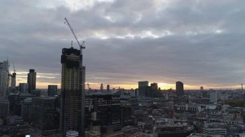 Skyscraper being built in densly populated area at sunset, drone aerial 4K Stock Footage 101156887