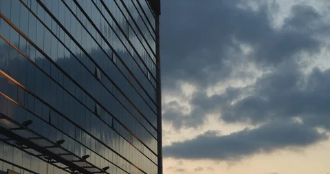 Skyscraper building at sunset with glass reflection of blue sky and clouds Stock Footage 123613604