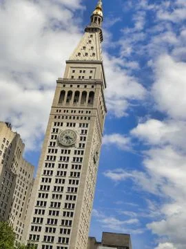 A skyscraper with a clock tower atop, piercing the blue sky New York USA Stock Photos