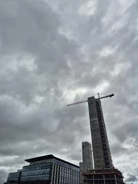 Skyscraper construction crane against dramatic cloudy sky Fotos de archivo