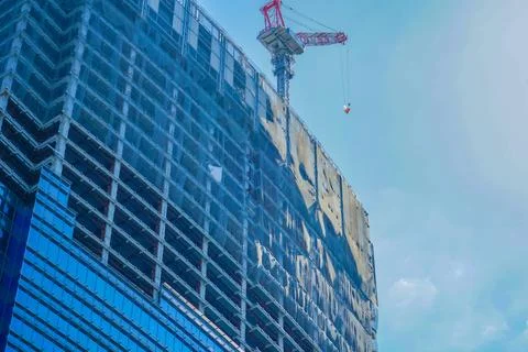 Skyscraper construction crane and blue sky Stock Photos