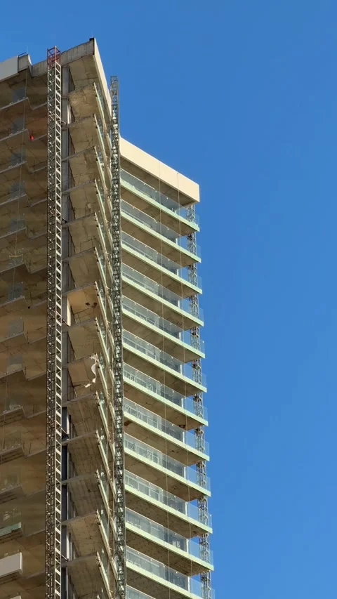 Skyscraper construction site against clear blue sky with scaffolding and gl.. Stock Footage 341418938