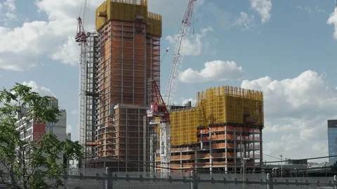 Skyscraper Construction Site with Train Running in Front Stock Footage 77283043