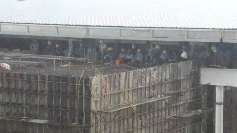 Skyscraper construction workers working building rainy day. Construction safety Stock Footage 225936638