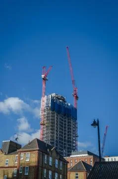 Skyscraper construction with working crane Stock Photos