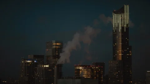 Skyscraper in Evening with glowing lights and smoke Stock Footage