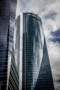 Skyscraper with glass facade and clouds reflected in windows Stock Photos