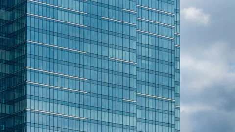 Skyscraper office building facade, sky clouds reflected on surface windows glass Stock Footage 160616603