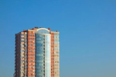 Skyscraper or flat block building on clear blue sky background. Closeup view  스톡 사진