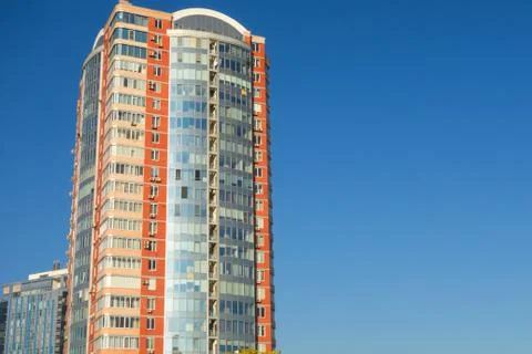 Skyscraper or flat block building on clear blue sky background. Closeup view  Stock-Fotos