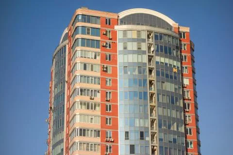 Skyscraper or flat block building on clear blue sky background. Closeup view  Stock Photos
