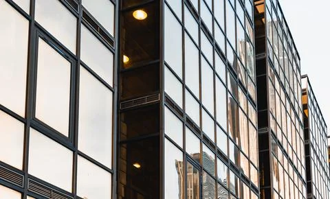 The skyscraper is reflected in the windows of the facade of a modern glass Stock Photos