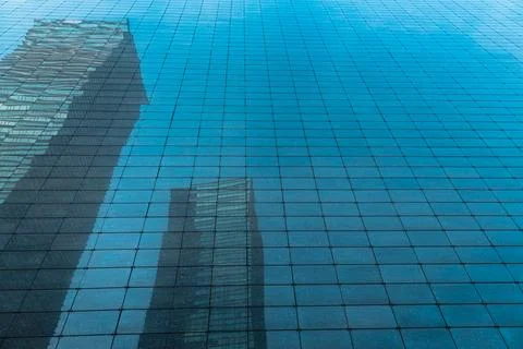 The skyscraper is reflected in the windows of the facade of a modern glass Stock Photos