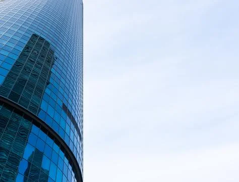 The skyscraper is reflected in the windows of the facade of a modern glass Stock Photos