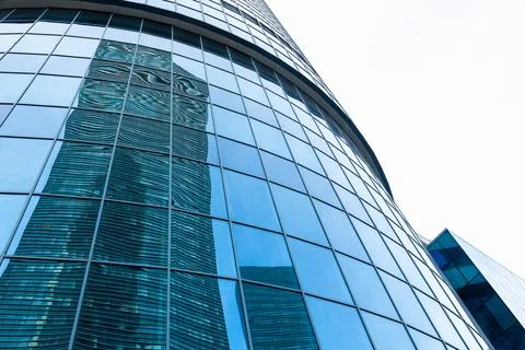 The skyscraper is reflected in the windows of the facade of a modern glass Stock Photos