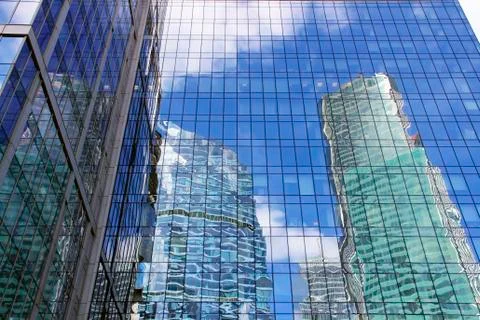 The skyscraper with the reflection of the blue sky in the Windows Stock Photos