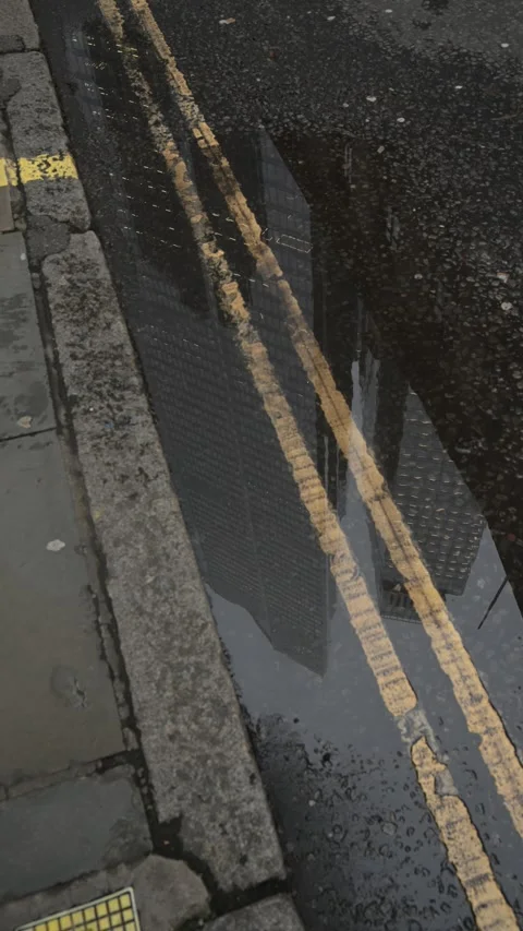 Skyscraper Reflections in Rain Puddle on City Street – Vertical Video Stock Footage 328667750