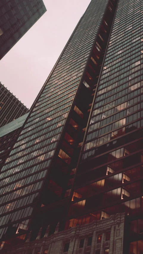Skyscraper stands tall against a cloudy sky in an urban setting Stock Footage 342952006