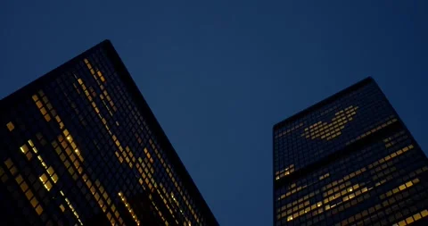 Skyscraper towers reflect evening glow as skyscraper windows illuminate city Stock Footage 314468063