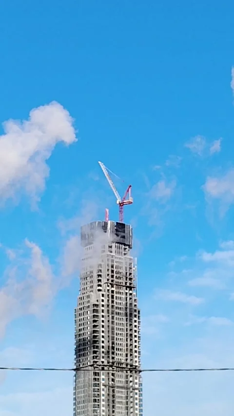 A skyscraper under construction against a bright blue sky. Stock Footage 321375673