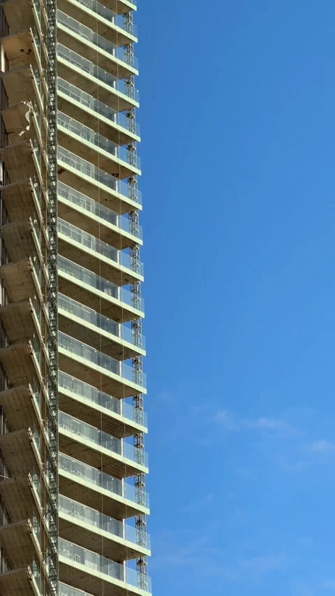 Skyscraper under construction against clear blue sky, vertical architectura.. Stock Footage 336556238