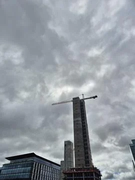 Skyscraper under construction against dramatic cloudy sky Stock Photos