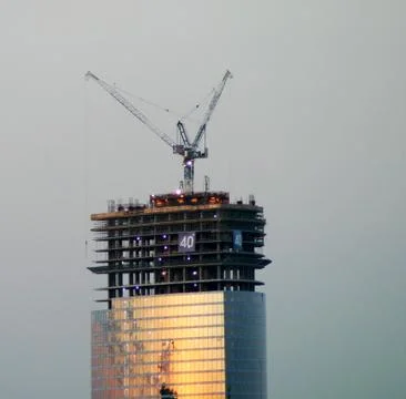 Skyscraper under construction on the background of the evening sky Stock Photos