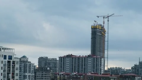 Skyscraper under construction with cranes against cloudy sky. Construction site Stock Footage 281683912