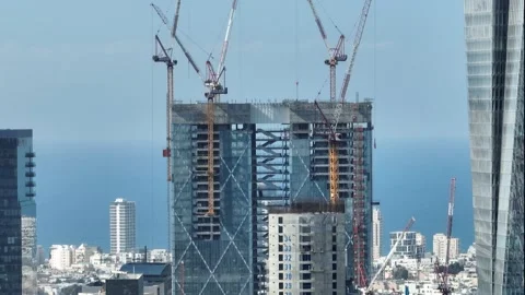 Skyscraper under construction with cranes and a staircase suspended in  air Stock Footage 228115536