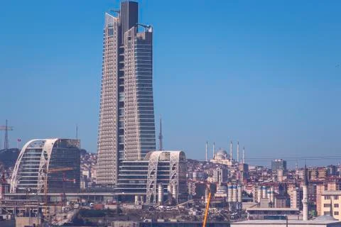 Skyscraper is under construction with a huge mosque in the background. Stock Photos