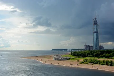 A skyscraper under construction on the seashore under the sky changing from.. Stock Photos