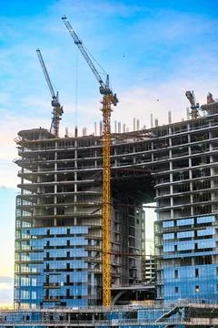Skyscraper under development with cranes and workers Foto stock