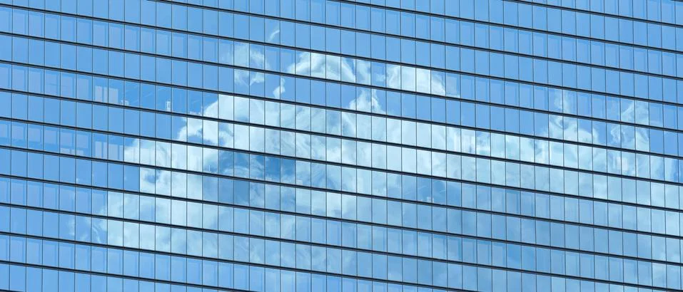 Skyscraper windows with white clouds and sky reflection Foto stock