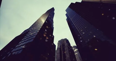 Skyscrapers reaching high into the cloudy sky in an urban setting Ilustración de archivo