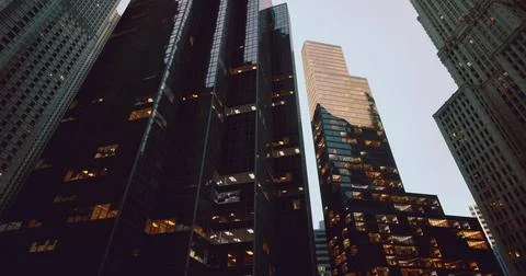 Skyscrapers reflecting evening light in a bustling urban environment Ilustración de archivo