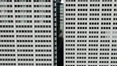 Skyscrapers with Windows Arranged in a Grid Pattern, with Cars Passing the Gaps Vídeos de archivo 335807311
