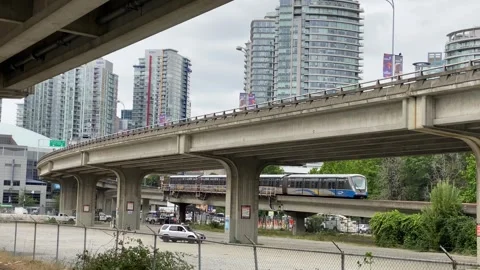 Skytrain passes twinned bridge and downtown city Stock Footage 281703799
