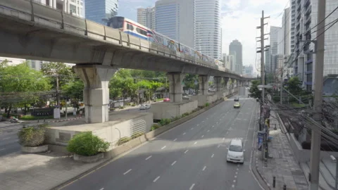 Skytrain passing above Sathon Road. Vertical panning motion Stock Footage 99133655