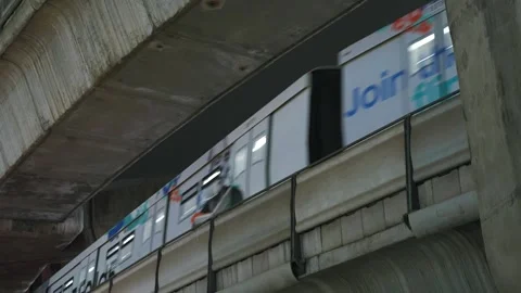 Skytrain passing by massive concrete viaduct in Bangkok city center at night Stock Footage 254702562