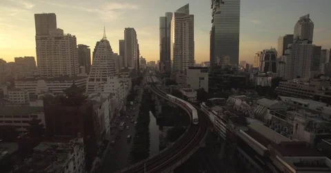 Skytrain in Silom District At Sunrise, Central Bangkok, Thailand, Aerial Video stock 79022373
