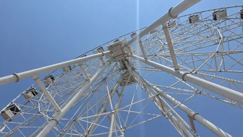 Skyward perspective of large white amusement ride with clean blue background Stock Footage 341774644