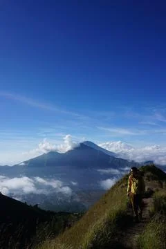 Skyward Summit, Asian Model on Mount Batur, Carrying Hiking Gear amidst Clo.. Stock Photos
