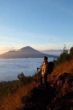 Skyward Summit, Asian Model on Mount Batur, Carrying Hiking Gear amidst Clo.. Stock Photos