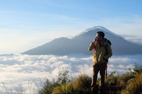 Skyward Summit, Asian Model on Mount Batur, Carrying Hiking Gear amidst Clo.. Stock Photos