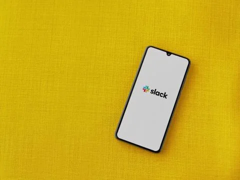 Slack app launch screen with logo on the display of a black mobile smartphone Stock Photos