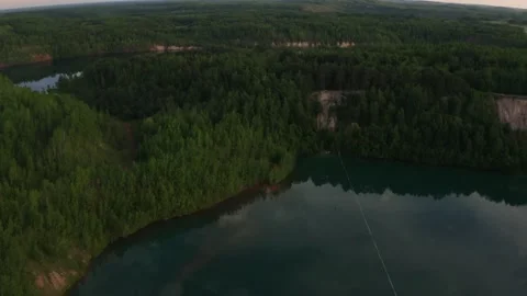 Slackline balanced walk over large chasm of pristine water and woods. High 3 Stock Footage 158402833