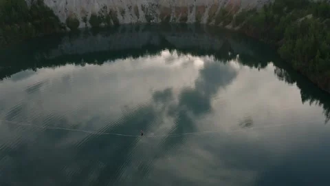 Slackline balanced walk over large chasm of pristine water and woods. High 8 Stock Footage 158402905